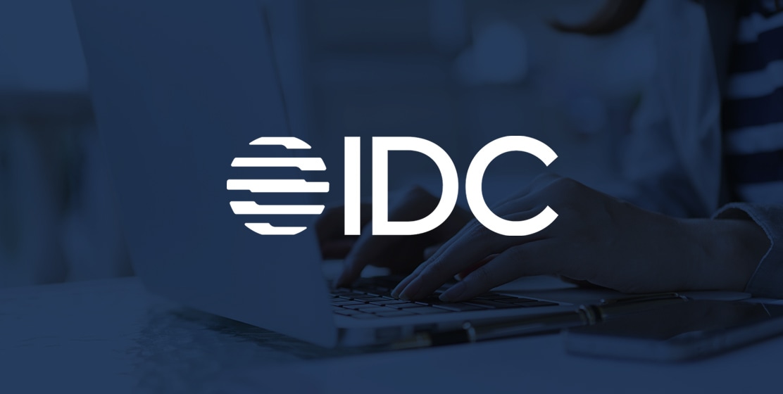 ラップトップの画像の上に重ね合わせられた International Data Corporation（IDC）社のロゴ